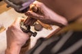 A male jeweler fixes precious stones on a silver pendant.