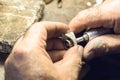 Jeweler polishing a ring using a sandpaper on a slotted mandrel.