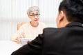Male job applicant Asians are Interview with an elderly Asian woman manager in an office