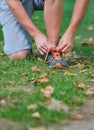 Male jogger tying laces on his shoes outside