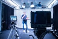 Journalist in a television studio is talking into a microphone, blurry film cameras Royalty Free Stock Photo