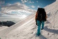 Male journeyman hikes up the snowy mountain