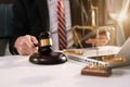 Male judge in a courtroom the gavel, working with digital tablet computer on wood table in office. Royalty Free Stock Photo