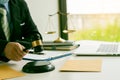 A male judge in the courtroom on a wooden table and a counselor or lawyer working in the office. A law with golden hammers and sca Royalty Free Stock Photo