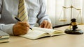 A male judge in the courtroom on a wooden table and a counselor or lawyer working in the office. A law with golden hammers and sca Royalty Free Stock Photo