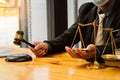 A male judge in the courtroom on a wooden table and a counselor or lawyer working in the office. A law with golden hammers and sca Royalty Free Stock Photo