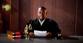 Male Judge Reading Documents While Sitting At Desk