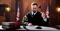 Male Judge Reading Documents While Sitting At Desk Royalty Free Stock Photo