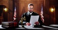 Male Judge Reading Documents While Sitting At Desk Royalty Free Stock Photo