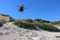 Male jumping off the sand dunes at Cottesloe Beach