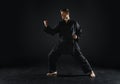 Male karate fighter in black kimono, combat stance