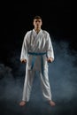 Male karate fighter in white kimono and red gloves