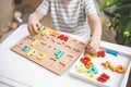 Male kid playing with wooden eco friendly alphabet letters board on table top view intellectual game Royalty Free Stock Photo