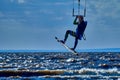 A male kiteboarder jumps above the surface of the water of a large river.