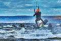 A male kiter jumps over a large lake. Close-up