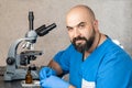 Male laboratory assistant examining biomaterial samples in a microscope Royalty Free Stock Photo