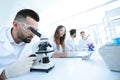 Male laboratory technician looking at samples in the microscope Royalty Free Stock Photo