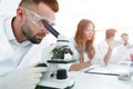Male laboratory technician looking at samples in the microscope Royalty Free Stock Photo