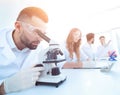 Male laboratory technician looking at samples in the microscope Royalty Free Stock Photo