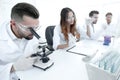 Male laboratory technician looking at samples in the microscope Royalty Free Stock Photo
