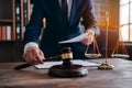 Male lawyer with contract papers and gavel in courtroom, justice concept