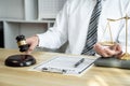 Male lawyer or jurist working with litigation contract paper documents of the estate lawsuit, Law books and wooden gavel on table