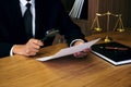 Male lawyer reading legal contract agreement and examining documents with magnifying glass in courtroom Royalty Free Stock Photo