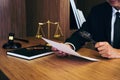 Male lawyer reading legal contract agreement and examining documents with magnifying glass in courtroom Royalty Free Stock Photo