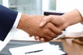 Male lawyer shaking hands with woman over table