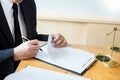 Male lawyer working with contract papers and reading law book in a courtroom, justice and law concept while presiding over trial