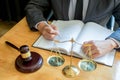 Male lawyer working with contract papers and reading law book in a courtroom, justice and law concept while presiding over trial