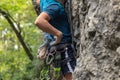 Male lead climber with equipment, climbing a cliff