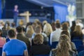 Male Leader Lecturer Speaking In front of the Large Group of People.