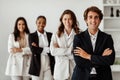 Male leadership concept. Diverse business team standing in line with folded arms and smiling at camera posing in office