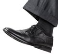 Male left foot in black shoe takes a step