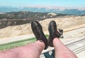 Male legs in black, leather sneakers. shoes made from natural, breathable materials. feet on the background of mountains from a Royalty Free Stock Photo