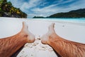 Male legs feet in focus. Enjoying relaxing at tropical paradise beach Royalty Free Stock Photo