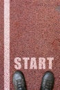 male legs and shoes standing to starting line. top view. Start line on rubber track. Start point of run competition