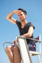 Male life guard sitting on chair on a summer day