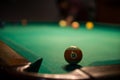 Male lines up billiard shot to sink a ball by the corner pocket