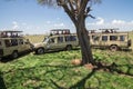 Male lion surrounded by safari tourists