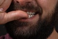male lips with untrimmed beard at closeup. Close up of male part of face. man bites his nails. Bad habit.