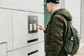 A male local resident or tourist clicks on the doorphone button or calls the intercom. Arrival and call from street to Royalty Free Stock Photo