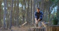 Male logger chopping wood with an axe in the forest 4k