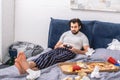 male loner playing video game on bed