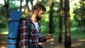 Male lost in forest using compass to navigate, finding way out from woods Royalty Free Stock Photo