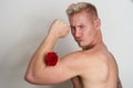 Male lover flexing muscle with a flower