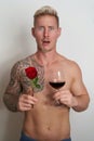 Male lover looking shocked with a flower and a glass of wine