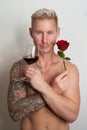 Male lover posing with a flower and a glass of wine