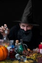 A male mage alchemist brews a potion. Halloween Holiday